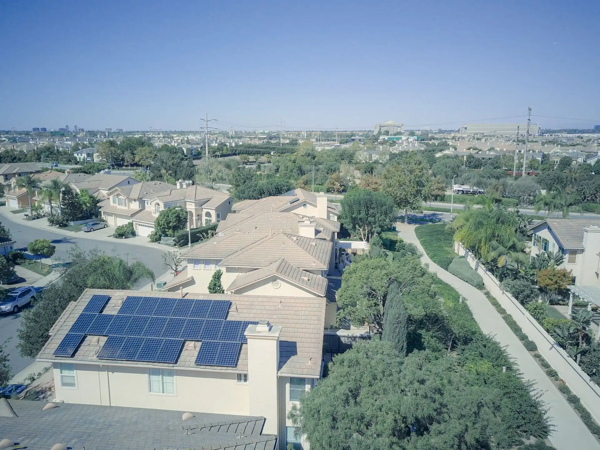 Vista aérea de un barrio residencial con paneles solares en un tejado.